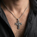 Load image into Gallery viewer, Oxidized Saint Michael pendant with winged archangel and shield worn on the neck in a lifestyle jewelry shot, styled against the chest for a bold and protective look