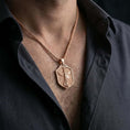 Load image into Gallery viewer, Rose gold plated Saint Michael shield pendant necklace worn on the neck, presented in a close-up lifestyle shot with a refined masculine aesthetic.