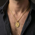 Load image into Gallery viewer, Gold plated Saint Nicholas pendant necklace worn on the neck, captured on a human model in a premium dark-toned lifestyle frame.