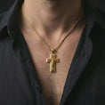 Load image into Gallery viewer, Gold plated Jesus Ascension cross pendant necklace worn on the neck, captured on a human model in a premium dark-toned lifestyle frame.