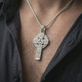Load image into Gallery viewer, Polished silver Celtic cross pendant necklace worn on the neck, shown against the chest in a clean and elegant everyday wear composition.