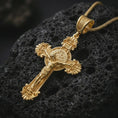Load image into Gallery viewer, Gold plated Saint Benedict crucifix necklace presented on porous volcanic rock, highlighting the ornate gothic cross design in a luxurious close-up jewelry image.