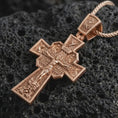 Load image into Gallery viewer, Rose gold plated Orthodox cross pendant necklace on dark volcanic rock, photographed in a detailed premium studio macro view.
