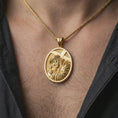 Load image into Gallery viewer, Gold plated Jesus carrying cross pendant necklace worn on the neck, captured on a human model in a premium dark-toned lifestyle frame.