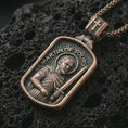Load image into Gallery viewer, Bronze Saint Martin of Tours pendant necklace with an oxidized finish resting on textured volcanic rock, captured in a close-up premium studio composition.