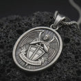 Load image into Gallery viewer, Sterling silver Saint Michael Archangel pendant necklace with an oxidized finish resting on textured volcanic rock, captured in a close-up premium studio composition.