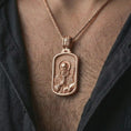 Load image into Gallery viewer, Rose gold plated Saint Benedict dog tag pendant necklace worn on the neck, presented in a close-up lifestyle shot with a refined masculine aesthetic.