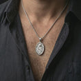 Load image into Gallery viewer, Polished silver Saint Rita pendant necklace worn on the neck, shown against the chest in a clean and elegant everyday wear composition.