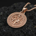 Load image into Gallery viewer, Rose gold plated Saint Benedict medal pendant necklace on dark volcanic rock, photographed in a detailed premium studio macro view.