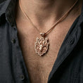 Load image into Gallery viewer, Rose gold plated stag pendant with flower-adorned antlers and artistic forest detailing worn on the neck in a refined lifestyle shot with a warm and elegant presentation