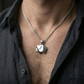 Load image into Gallery viewer, Polished silver elephant necklace with geometric folded form worn on the neck in a close lifestyle frame, highlighting the clean origami lines and modern animal silhouette