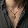 Load image into Gallery viewer, Rose gold plated serpent necklace with intertwined snake motif, detailed scale relief, and balanced knot design worn on the neck in a refined lifestyle shot with a warm and distinctive presentation