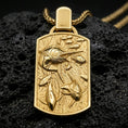 Load image into Gallery viewer, Gold plated swordfish pendant with detailed underwater scene, dynamic fish movement, and refined ocean-inspired rectangular design showcased on black volcanic rock in a refined macro jewelry image