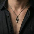 Load image into Gallery viewer, Oxidized snake pendant with winding serpent silhouette worn on the neck in a lifestyle jewelry shot, styled against the chest for a bold and symbolic statement look