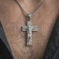 Load image into Gallery viewer, Polished silver symbolic cross pendant worn on the neck, shown against the chest in a clean and elegant everyday wear composition.