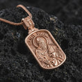 Load image into Gallery viewer, Rose gold plated Saint Paul dog tag pendant necklace on dark volcanic rock, photographed in a detailed premium studio macro view.