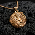 Load image into Gallery viewer, Gold plated tiger pendant with curled feline silhouette, engraved stripe texture, and refined jungle-inspired animal motif showcased on black volcanic rock in a refined macro jewelry image