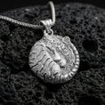 Load image into Gallery viewer, Polished silver tiger necklace with resting wild cat design, intricate facial detailing, and wrapped tail composition placed on textured volcanic rock in a premium studio product shot
