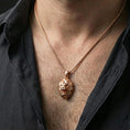 Load image into Gallery viewer, Rose gold plated geometric lion necklace with low poly lion head, angular faceted structure, and modern wilderness-inspired form worn on the neck in a refined lifestyle shot with a warm and sophisticated presentation