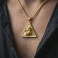 Load image into Gallery viewer, Gold plated all-seeing eye pendant necklace worn on the neck, captured on a human model in a premium dark-toned lifestyle frame.