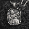 Load image into Gallery viewer, Sterling silver Spartan warrior pendant necklace with an oxidized finish resting on textured volcanic rock, captured in a close-up premium studio composition.