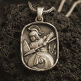 Load image into Gallery viewer, Bronze Spartan warrior pendant necklace with an oxidized finish resting on textured volcanic rock, captured in a close-up premium studio composition.
