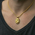 Load image into Gallery viewer, Gold plated howling wolf pendant necklace worn on the neck, captured on a human model in a premium dark-toned lifestyle frame.