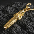 Load image into Gallery viewer, Gold plated King Tut pendant necklace presented on porous volcanic rock, highlighting the ancient Egyptian dagger-inspired form in a luxurious close-up jewelry image.