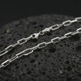 Load image into Gallery viewer, Polished silver cable link chain necklace displayed on black volcanic rock, shown in a refined macro product shot with elongated anchor links and clean metal detail.
