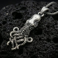 Load image into Gallery viewer, Sterling silver octopus pendant necklace with an oxidized finish resting on textured volcanic rock, captured in a close-up premium studio composition.