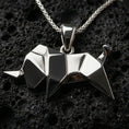 Load image into Gallery viewer, Polished silver origami elephant pendant necklace displayed on black volcanic rock, shown in a refined macro product shot with sharp geometric folds.