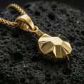 Load image into Gallery viewer, Gold plated origami tortoise pendant necklace presented on porous volcanic rock, highlighting the angular shell design in a luxurious close-up jewelry image.