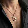 Load image into Gallery viewer, Rose gold plated bull pendant necklace worn on the neck, presented in a close-up lifestyle shot with a refined masculine aesthetic.