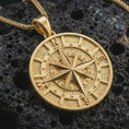 Load image into Gallery viewer, Gold plated compass pendant necklace presented on porous volcanic rock, highlighting the round nautical design in a luxurious close-up jewelry image.