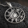 Load image into Gallery viewer, Sterling silver sun and moon pendant necklace with an oxidized finish resting on textured volcanic rock, captured in a close-up premium studio composition.