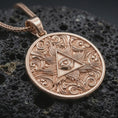 Load image into Gallery viewer, Rose gold plated Eye of Providence pendant necklace on dark volcanic rock, photographed in a detailed premium studio macro view.
