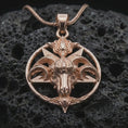 Load image into Gallery viewer, Rose gold plated Baphomet goat head pendant necklace on dark volcanic rock, photographed in a detailed premium studio macro view.