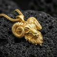 Load image into Gallery viewer, Gold plated ram head pendant necklace presented on porous volcanic rock, highlighting the bold Aries-inspired animal design in a luxurious close-up jewelry image.