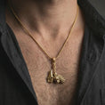 Load image into Gallery viewer, Gold plated paladin hammer pendant necklace worn on the neck, captured on a human model in a premium dark-toned lifestyle frame.