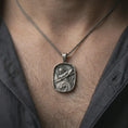 Load image into Gallery viewer, Oxidized Roman soldier pendant necklace worn on the neck, styled in a dark lifestyle portrait with an open shirt and masculine presentation.