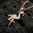 Load image into Gallery viewer, Rose gold plated origami flamingo pendant necklace on dark volcanic rock, photographed in a detailed premium studio macro view.