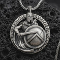 Load image into Gallery viewer, Sterling silver Spartan warrior pendant necklace with an oxidized finish resting on textured volcanic rock, captured in a close-up premium studio composition.