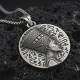 Load image into Gallery viewer, Sterling silver Nefertiti medallion pendant necklace with an oxidized finish resting on textured volcanic rock, captured in a close-up premium studio composition.
