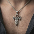 Load image into Gallery viewer, Oxidized Eye of Horus ankh pendant necklace worn on the neck, styled in a dark lifestyle portrait with an open shirt and symbolic presentation.