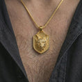 Load image into Gallery viewer, Gold plated fox shield pendant necklace worn on the neck, captured on a human model in a premium dark-toned lifestyle frame.