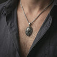 Load image into Gallery viewer, Oxidized lion head pendant necklace worn on the neck, styled in a dark lifestyle portrait with an open shirt and bold masculine presentation.