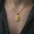 Load image into Gallery viewer, Gold plated ram head pendant necklace worn on the neck, captured on a human model in a premium dark-toned lifestyle frame.
