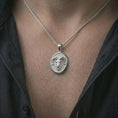 Load image into Gallery viewer, Polished silver ram head pendant necklace worn on the neck, shown against the chest in a clean and striking everyday wear composition.
