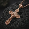 Load image into Gallery viewer, Rose gold plated Saint Benedict crucifix necklace on dark volcanic rock, photographed in a detailed premium studio macro view.