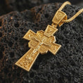 Load image into Gallery viewer, Gold plated Orthodox cross pendant necklace presented on porous volcanic rock, highlighting the intricate devotional cross design in a luxurious close-up jewelry image.
